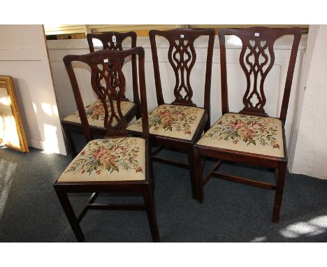A set of four Chippendale style mahogany dining chairs with pierced ribbon splats, drop-in tapestry seats, on square chamfere