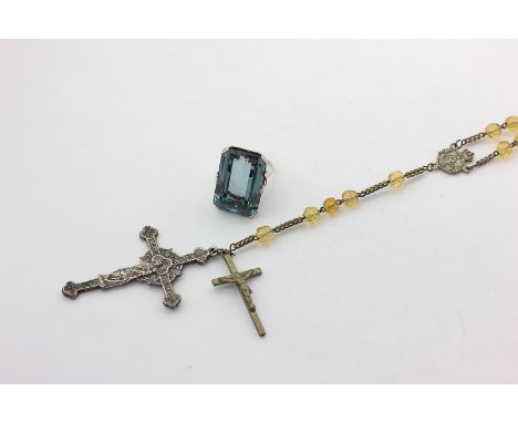 A blue topaz dress ring in 9ct white gold (not tested), and a French bead necklace hung with two crucifixes