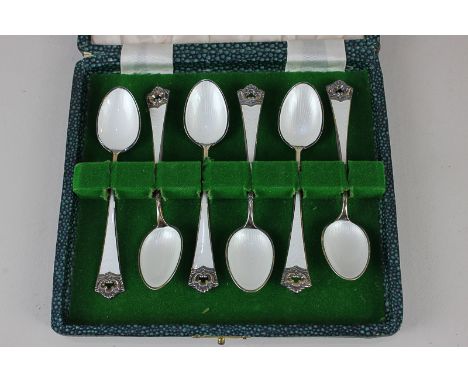 A cased set of six Norwegian silver gilt and white guilloche enamel tea spoons by David Andersen, with pierced scroll termina