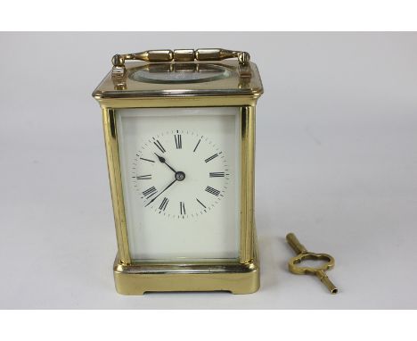 A brass carriage clock with bell striking mechanism, white dial with Roman numerals, 17.5cm high