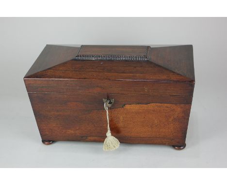 A 19th century rosewood sarcophagus shaped tea caddy with central well flanked by two lidded compartments, on bun feet, 27.5c