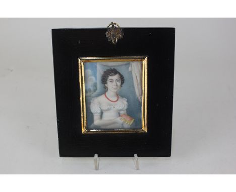 A 19th century portrait miniature on ivory depicting a young lady with waved brown hair and blue eyes, wearing a white gown a