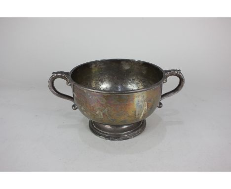 A George V silver two handled bowl on circular foot with leaf capped scroll handles, maker R &amp; S Garrard &amp; Co, London