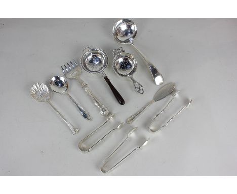 A George V silver tea strainer, a sauce ladle, two sugar tongs, two preserve spoons, a butler knife, gross weight 6.5oz, a si