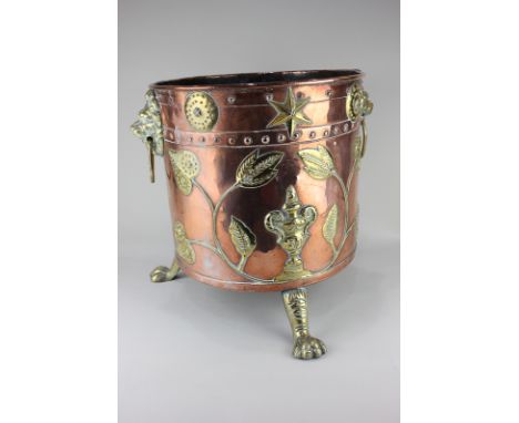 A studded copper and brass coal scuttle with two lion mask brass ring handles, decorated with urns, stars, circles and foliag