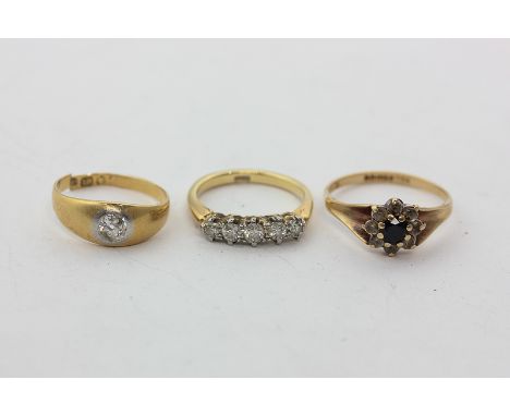 A diamond five-stone ring in 18ct gold, a gypsy set diamond ring in 18ct gold, and a sapphire cluster ring