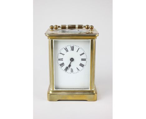 A brass carriage clock with white enamel dial and Roman numerals, 14cm high