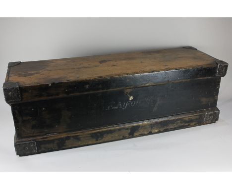 An early 20th century pine trunk with metal strengthened corners and two iron handles, with lock and key, possibly military o