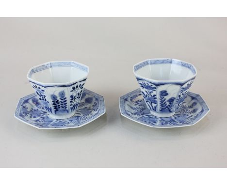 A pair of Chinese blue and white porcelain tea bowls and saucers, octagonal form decorated with panels of flowers, seal marks