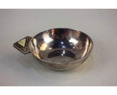 A George V silver tastevin, maker Robert E Stone, London 1931, signed R E Stone to base, hammered circular form with single h