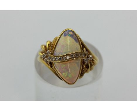 An opal and diamond ring of abstract form in 18ct yellow gold