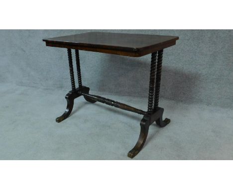 A Regency rosewood centre table on stretchered bobbin turned supports on swept feet terminating in brass caps. H.69 W.84 D.55