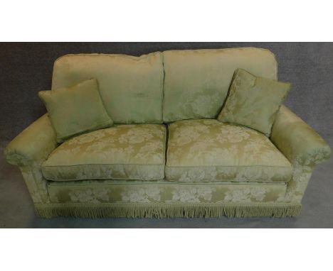 A two seater sofa in floral green upholstery. 77x188x85cm 