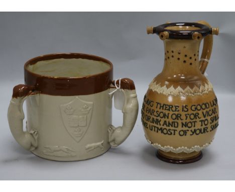 A Royal Doulton salt-glazed puzzle jug and a stoneware loving cup, the jug inscribed 'Within this jug there is good liquor/'T