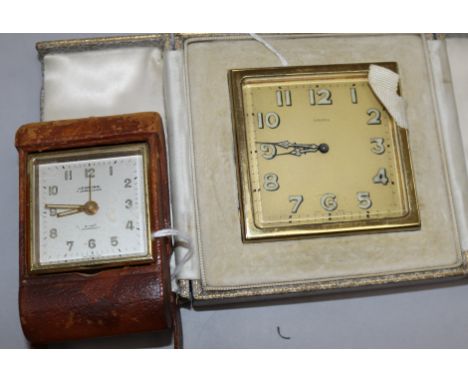 A Swiss gilt-metal travelling alarm clock in Asprey folding leather case and another smaller leather clock