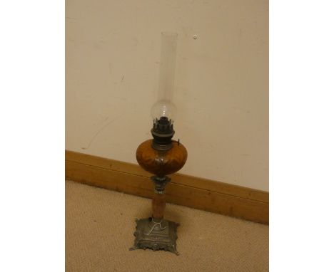 A late Victorian oil lamp with amber glass bowl on an onyx and metal base 