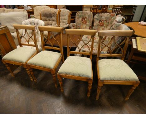 A set of four light beech dining chairs with green upholstered seats 