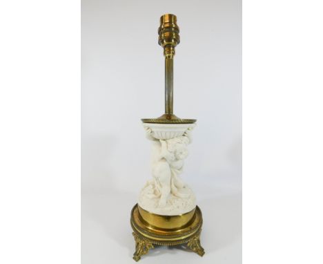 A Victorian parian lamp base on a gilt metal base modelled as cherubs wrestling, height to top of light fitting 35cms 