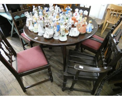 An Ercol oak drop leaf dining table and a set of six spindle back chairs with pink upholstered seats, four standards, two car