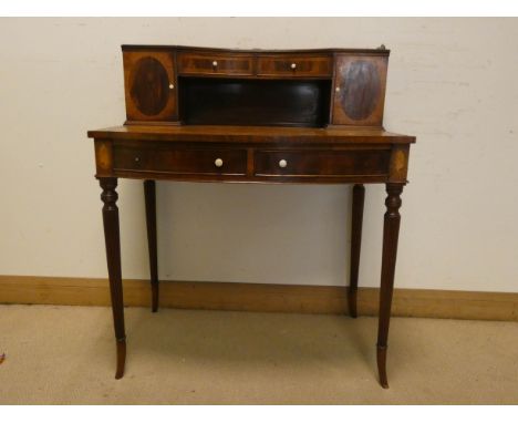 An Edwardian style inlaid mahogany bow front ladies Carlton House style desk with cupboard and drawer back, two drawers under