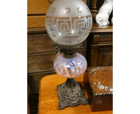 A Victorian iron based oil lamp with decorative pink glass bowl and a shade   Fount is glued, bottom glass bowl is glued at b