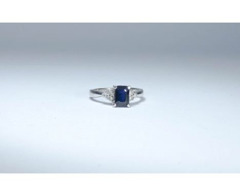 18ct white gold sapphire dress ring set with a trap cut dark blue sapphire to the centre flanked each size by white sapphires