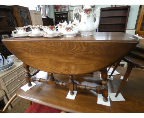 An Ercol Golden Dawn drop leaf coffee table standing on turned legs and stretcher base 