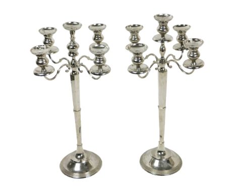 A pair of large stainless steel four branch - five light Candlesticks, on circular step bases, approx. 76cms (30") high. (2)
