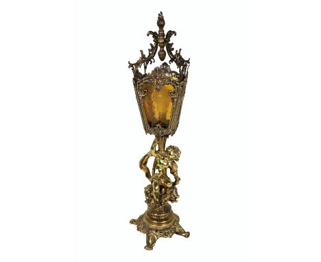 A 19th Century brass Lantern Lamp, with glass and decorative ormolu shade, with cherub support on circular base and pad feet.