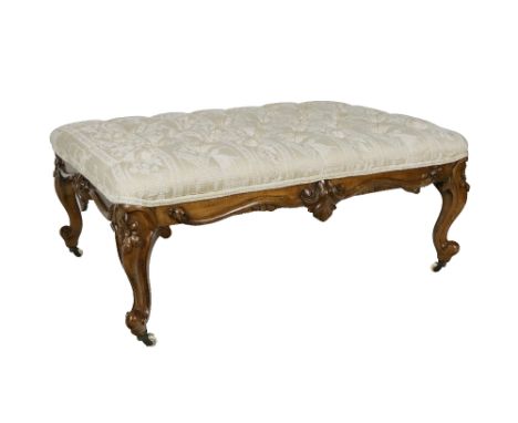 A large Victorian walnut framed Footstool, covered in cream deep button fleur de lys fabric with carved frieze on cabriole le