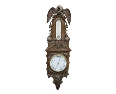 An oversized Victorian oak framed Barometer, with American eagle surmounted over a carved frame with inset thermometer and la