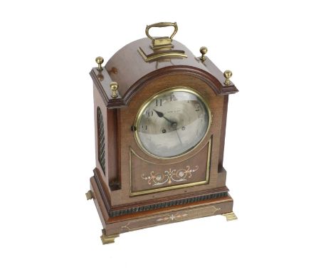 An attractive Irish mahogany cased Mantel Clock, Edwardian, with domed top with brass finials and carrying handle, over a sil