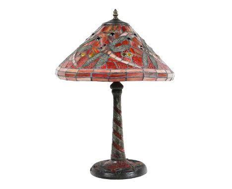 A Tiffany style Dragonfly Table Lamp, the glass shade of red colour with flying insect design, on a conforming metal base wit