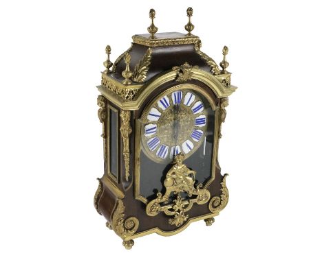 A French Boulle Mantel Clock, with overall ornate mounts and finials with enamel Roman numeral dial with figural glazed front