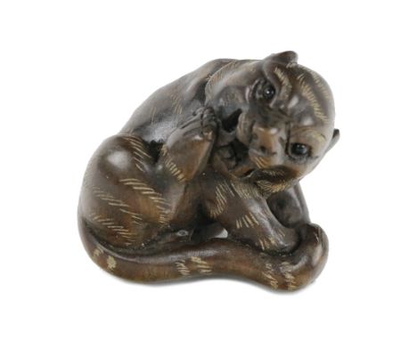 A fine quality early 20th Century Japanese carved Netsuke, of a recumbent tiger, with head turned with makers mark, approx. 3