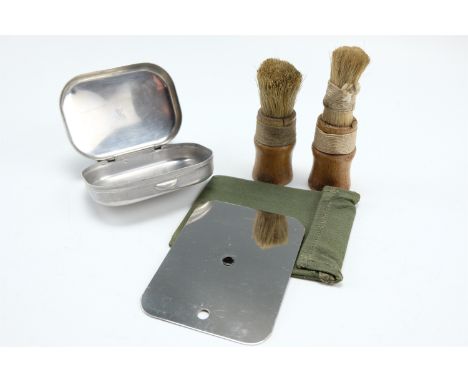 A 1945 British army tropical issue steel mirror, a soap tin and two shaving brushes