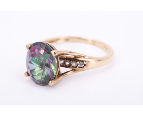 A modern 9 ct gold mystic topaz and spinel ring, having a 10 x 8 mm topaz set on a four prong gallery, elevated over 10 1.5 m