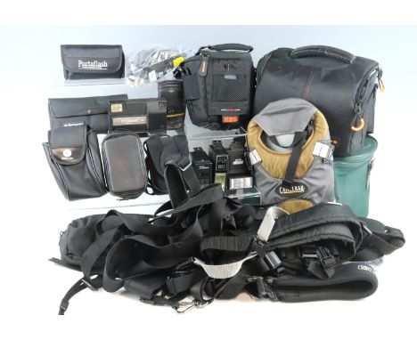 A large group of camera accessories, including light meters, flashes, camera bags, a tripod, etc