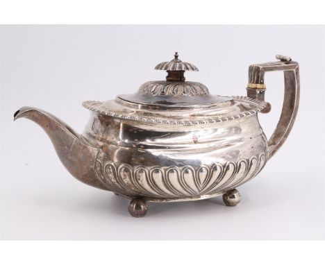 A George IV silver teapot, of compressed form decorated with gadrooning, bearing an engraved armorial crest, Edward Barton, L