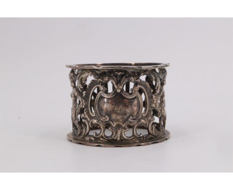 A Victorian silver napkin ring, having pierced and embossed decoration of putto either side of a vacant cartouche, with a tem