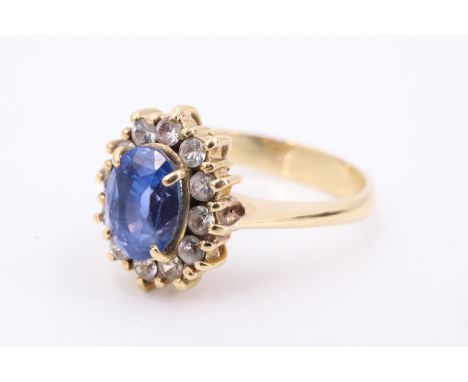 A blue and white sapphire 18 carat yellow metal ring, the 6 x 8 mm blue sapphire terraced above a surrounding gallery of 12 w