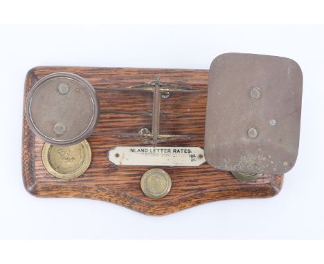 A Victorian set of desk-top postal / letter balance scales with weights, in brass and oak with printed Ivorine "Inland letter