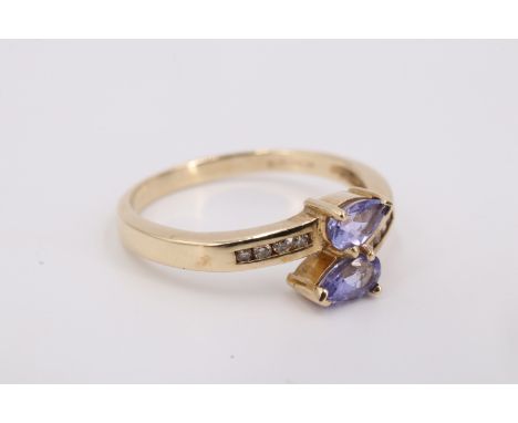 An iolite and diamond 9 ct gold crossover ring, having two 4.5 x 3 mm pear cut blue iolites terminating crossover shoulders e