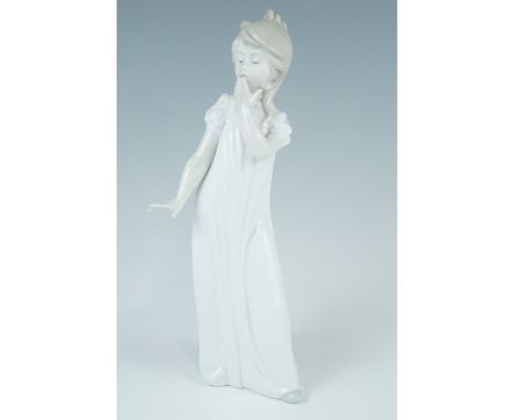 A Nao figurine of a young girl in night dress modelled holding her hand to her mouth, 29 cm