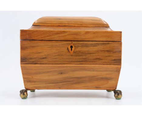 An early 19th Century walnut tea caddy, having string inlaid decoration, lion's mask loop handles and a vacant interior, on f