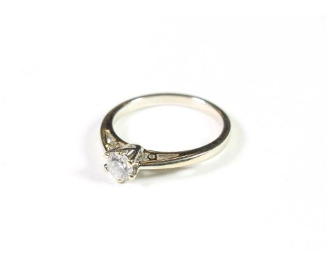 A diamond solitaire ring, the round brilliant cut diamond in a white claw setting, to a tapered shoulder plain polished shank