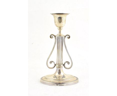 A Victorian Silver Candlestick, by George Howson, London, 1897 on an oval base, the stem formed as a lyre, with tapering sock