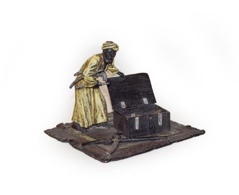 A cold painted bronze figure of a carpet seller, 13cm wide.  Some general paint chips and wear. 