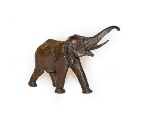 A patinated bronze model of an elephant, 9cm high by 14cm wide