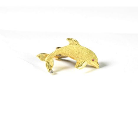 A synthetic ruby and diamond dolphin brooch, the realistically modelled dolphin with a yellow textured body, a round cut synt